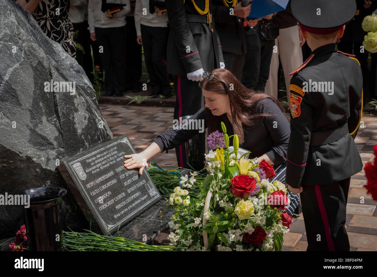 A mother mourns as she touches the name of her son engraved on a ...