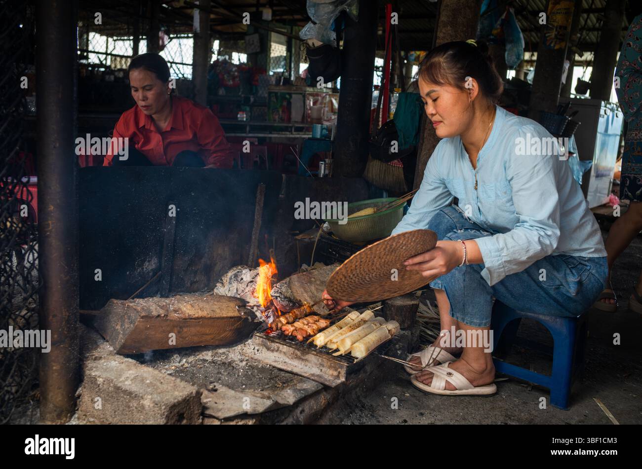 Cooks Using Tubes A White Thai ethnic minority woman cooks pork skewers and sticky rice ...