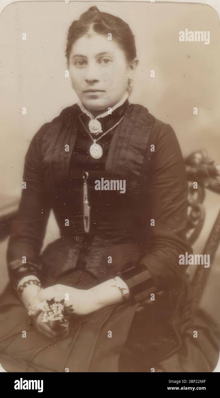 Bremen, Wolffram, Ernst, Portrait of a woman with necklace, sitting on a chair, verso - printed, This photo is part of an album., photograph, photo, carte-de-visite, album sheet, photos, E. WOLFFRAM/ PHOTOGRAPH/ BRE MEN/ 14, FEDELHÖREN/ PORTRAITS IN VERSCH. AUSFÜHRUNGEN./ IN EINFABRIG, Schwarz, BRAUN, ODER VIOLET/ IN NATÜRLICHEN AUTHEN FARBEN, height 82 mm, width 49 mm, photographer, 1887-05-01 - 1887-05-01, cardboard, paper, album print, albumin printing Stock Photo