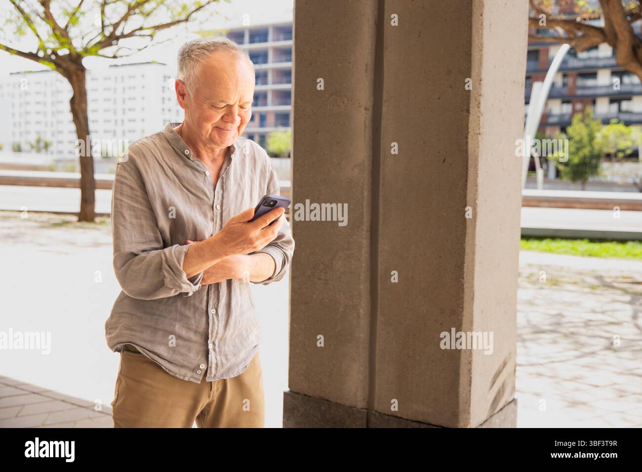 Senior man using smartphone outdoors. Man with phone Stock Photo