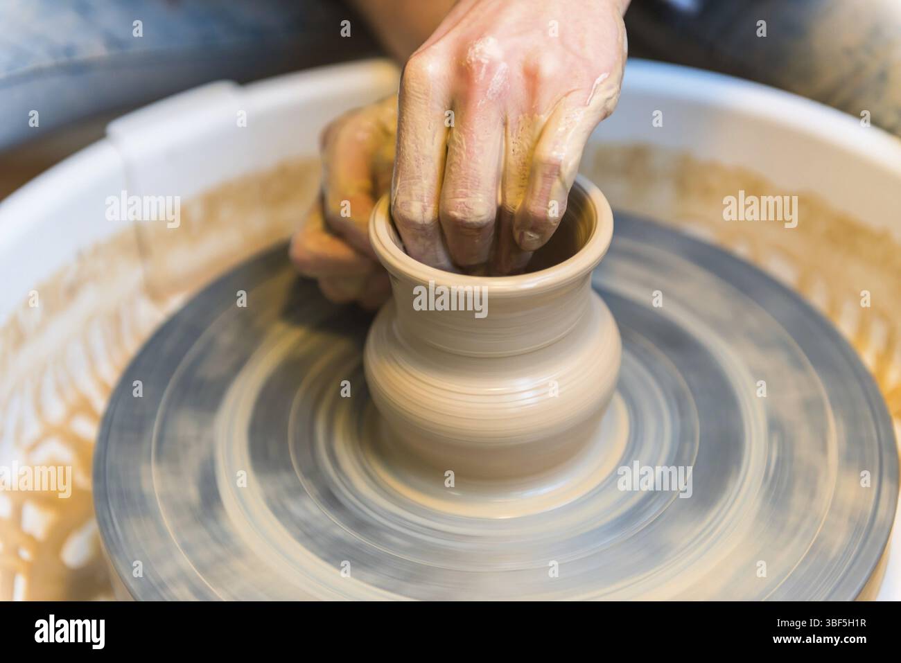Pottering - creating a clay cup in process. Shot with a small GRIP Stock Photo