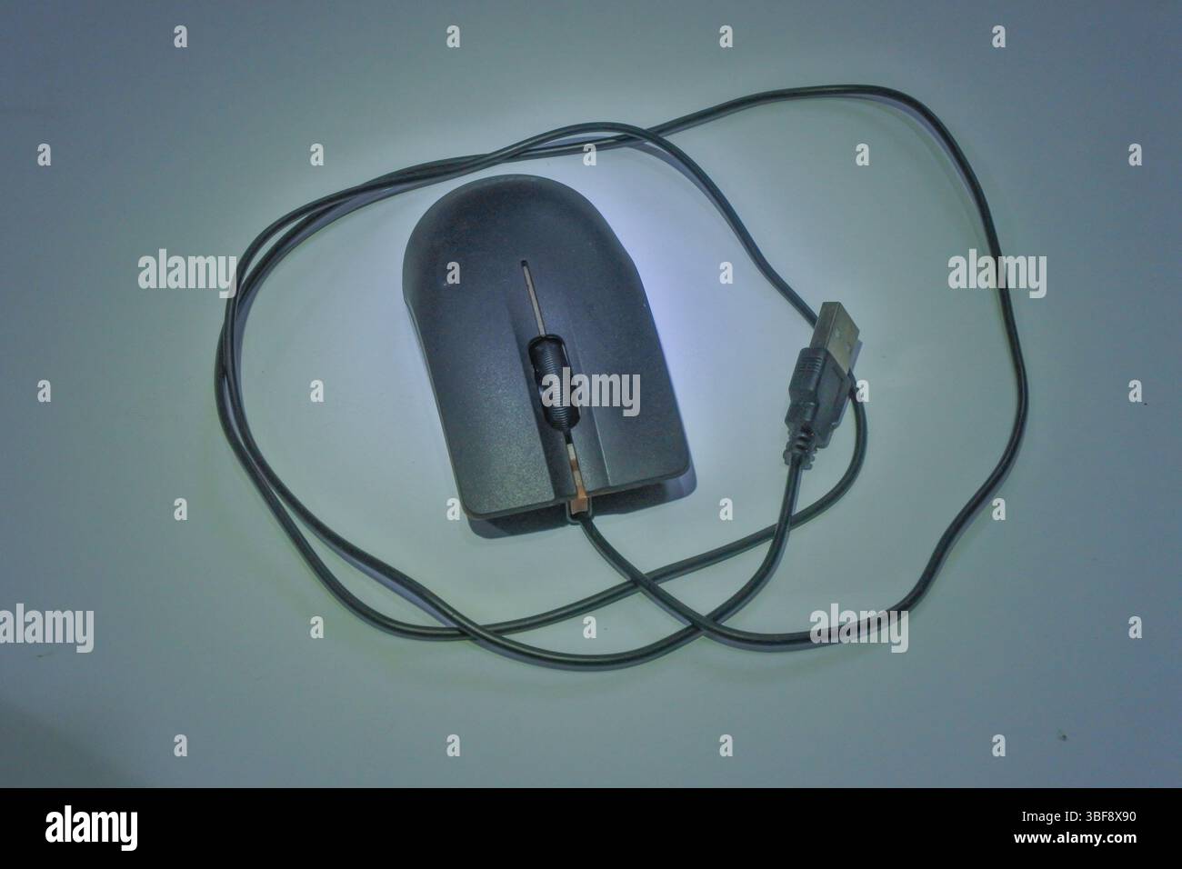 a black wired mouse with orange stripes made of plastic, with a gray background as an interactive controller on the computer Stock Photo