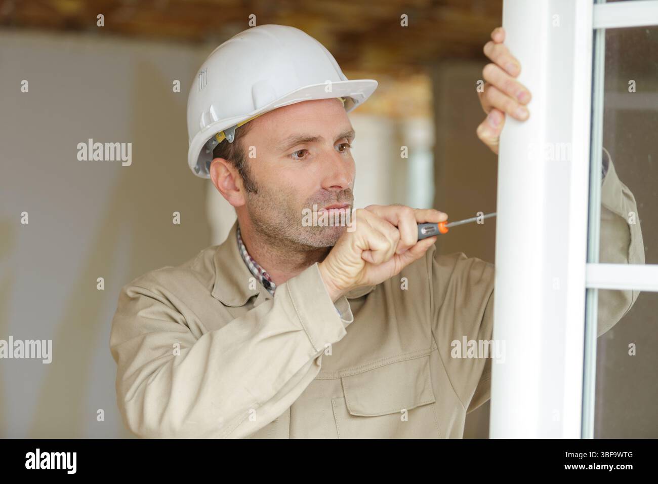smiling man is fixing a window handle Stock Photo