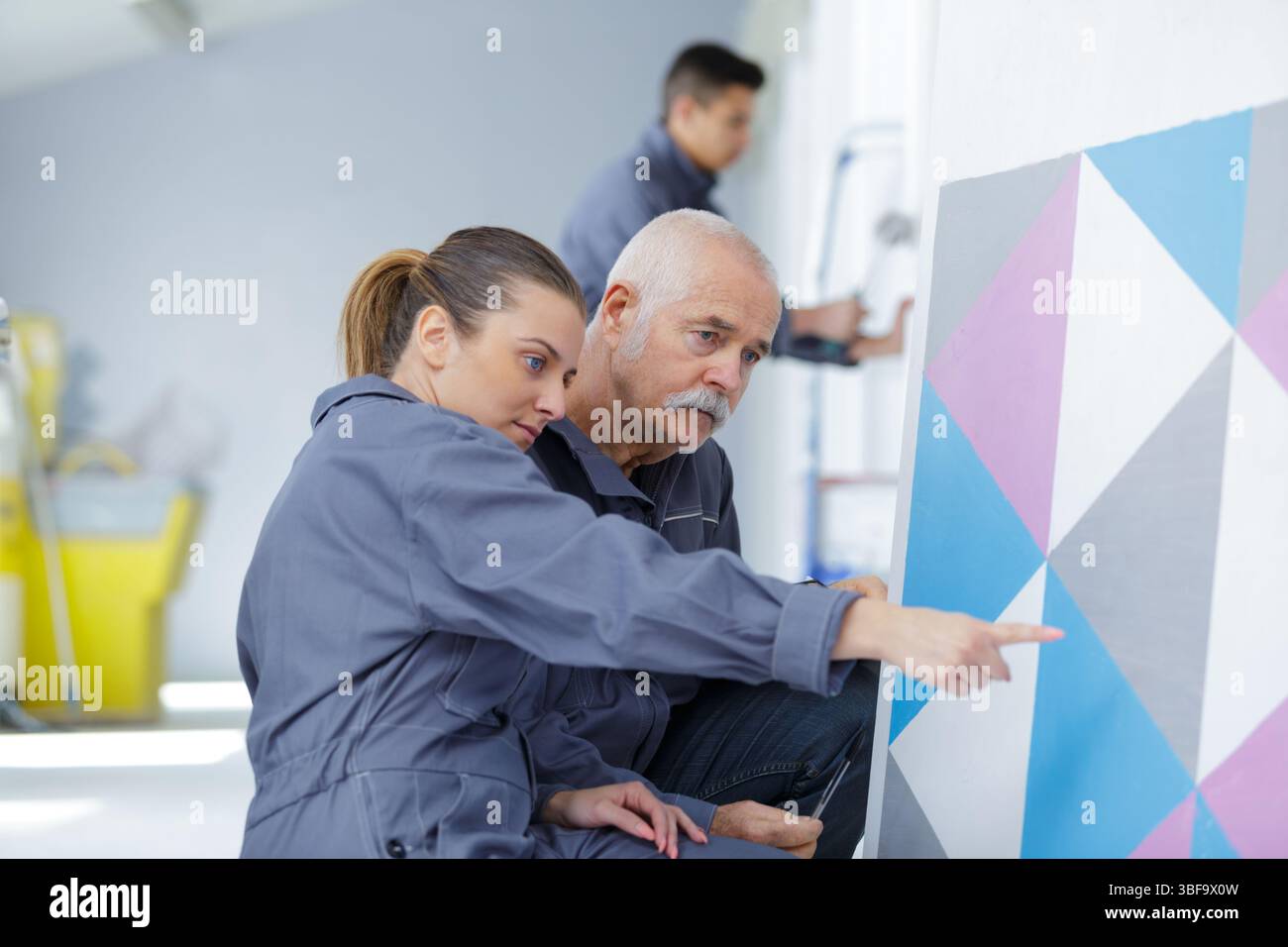 painter with apprentice in training room Stock Photo