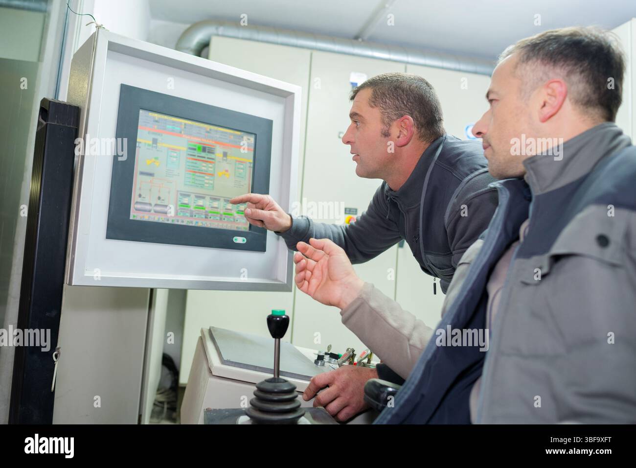 industrial workers looking at computer screen Stock Photo