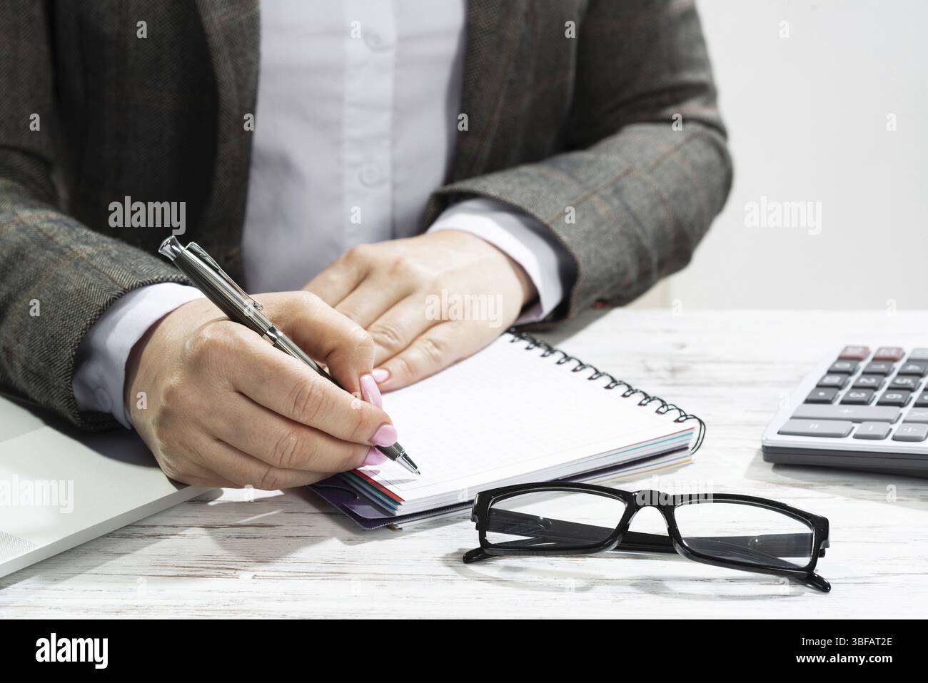 Close up woman hand holding pen. Businesswoman writing in notepad ...