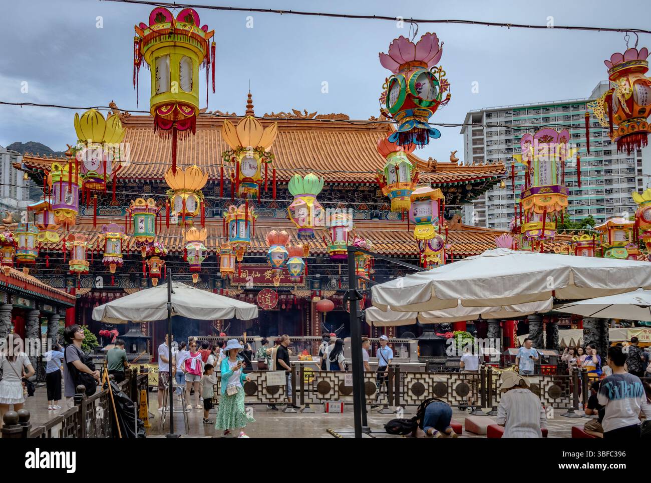 Wong Tai Sin Temple building and hanging lanterns located in Hong Kong City. Photo taken on a cloudy day Stock Photo