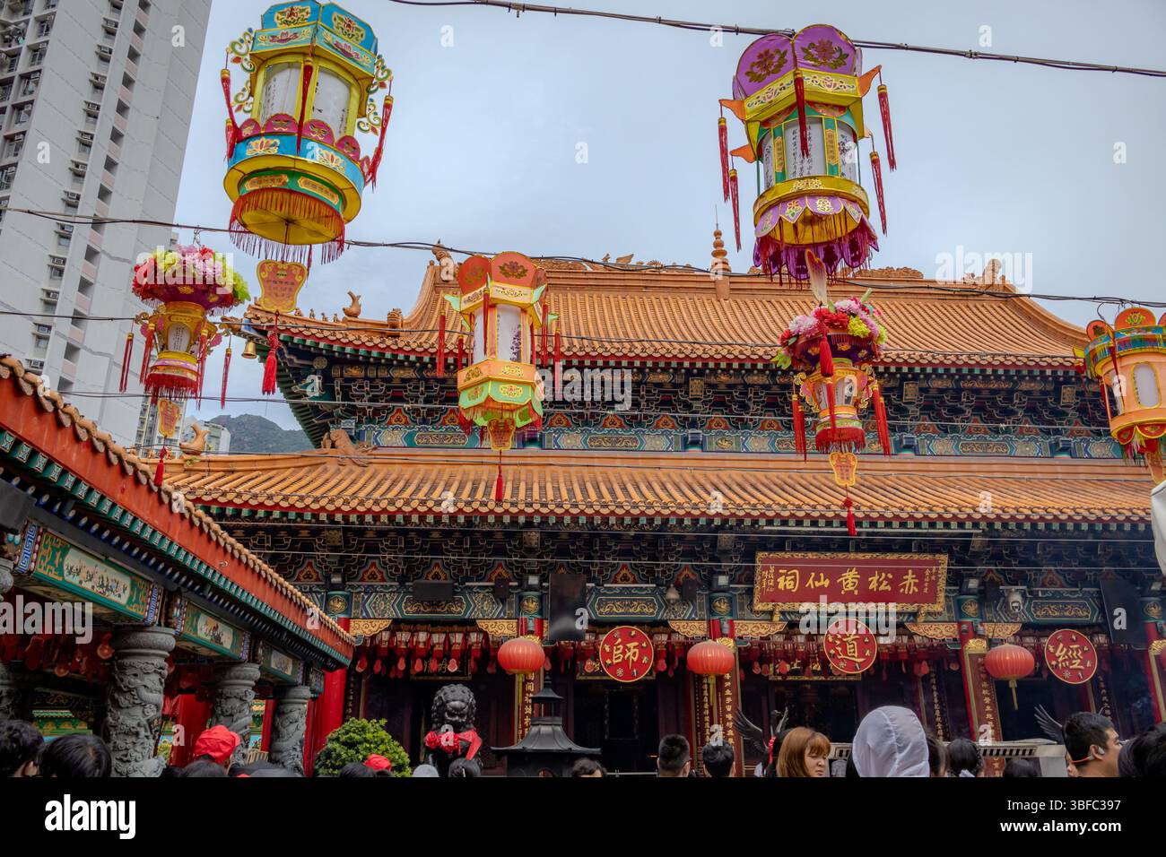 Wong Tai Sin Temple building and hanging lanterns located in Hong Kong City. Photo taken on a cloudy day Stock Photo