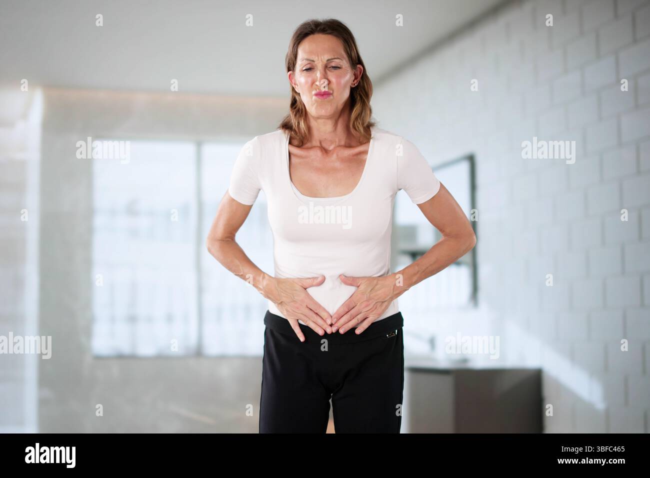 Woman Holding Stomach With Pain, Feeling Nauseous During Ectopic Pregnancy. Stock Photo