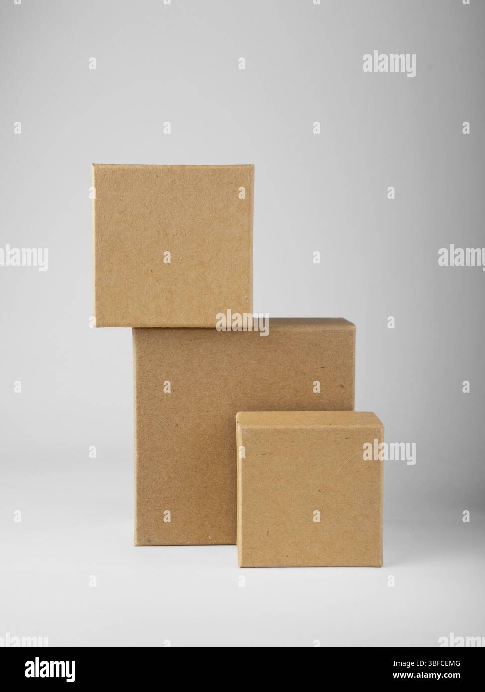 Three square cardboard boxes stand on white background, mockup Stock Photo