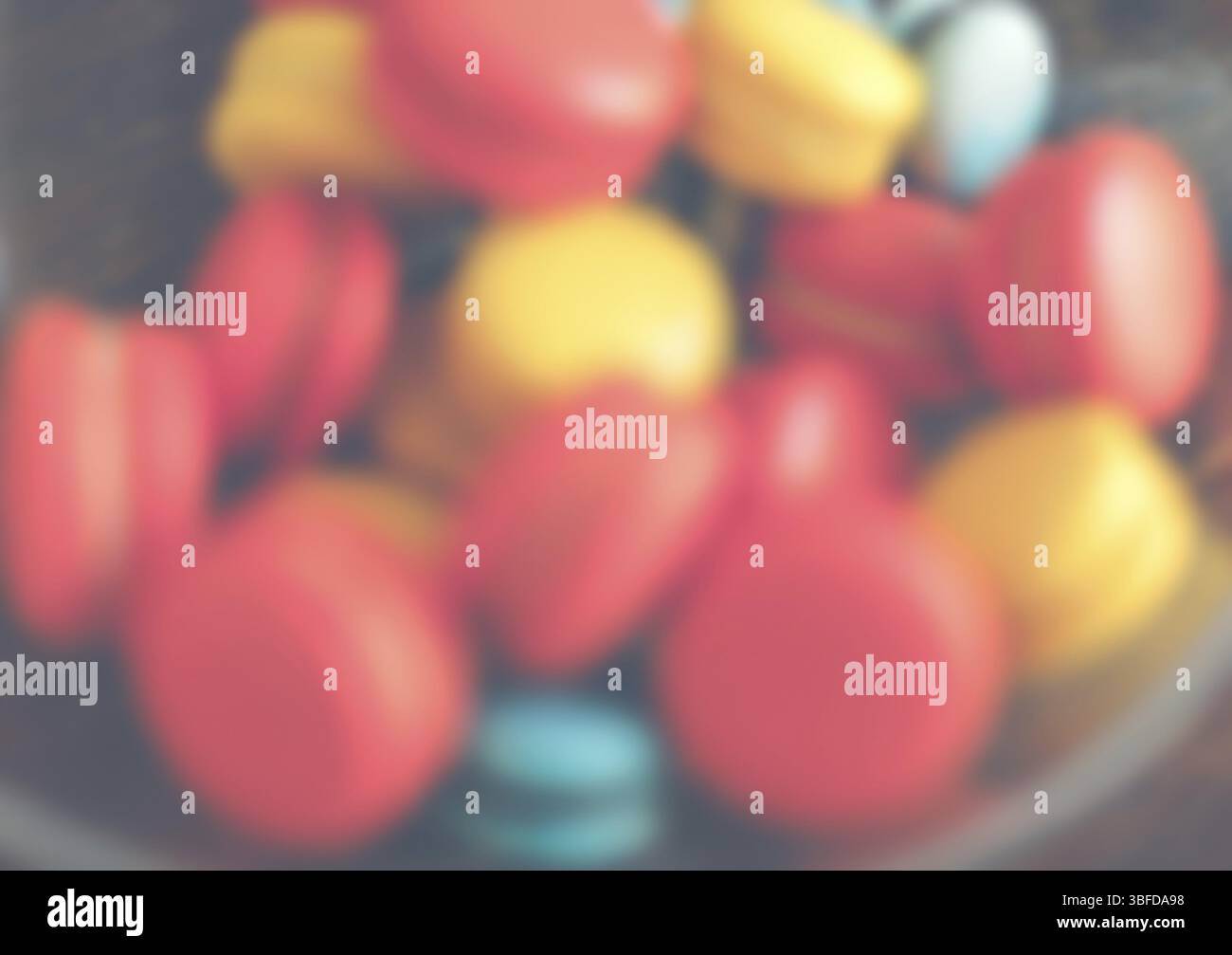 Bright macaroons in a glass bowl. Defocused shot Stock Photo