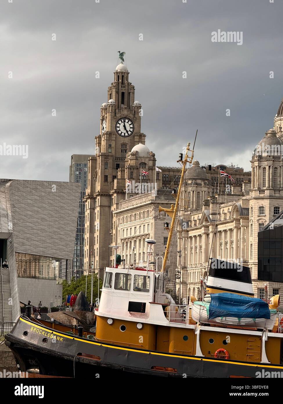 The Three Graces including Royal Liver building on Liverpool waterfront with boat named Brocklebank and Museum of Liverpool building in foreground - Smartphone Captured Stock Image