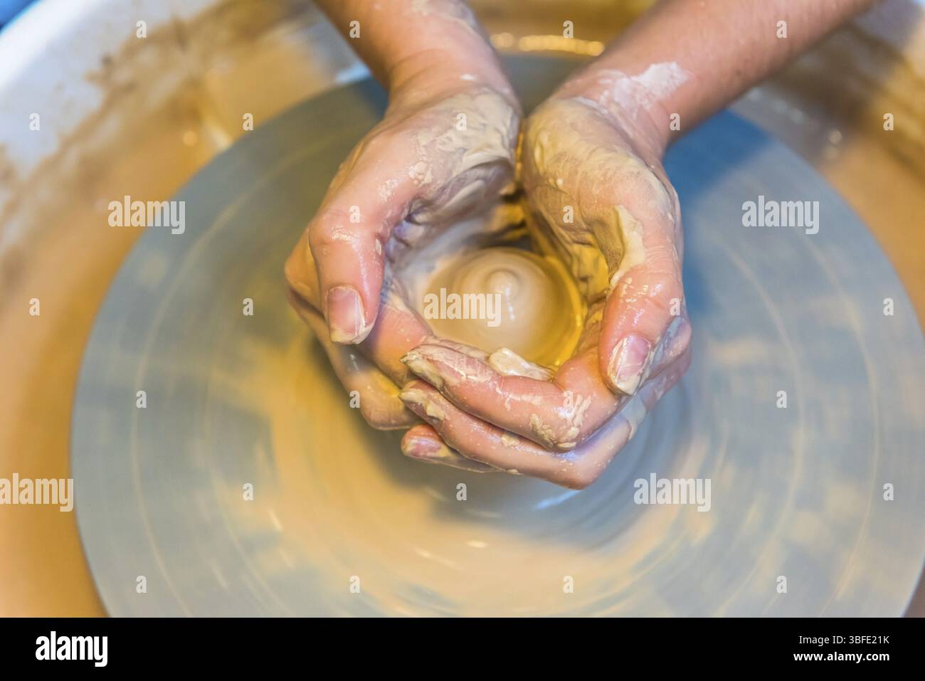 Pottering - creating a clay cup in process. Shot with a small GRIP Stock Photo