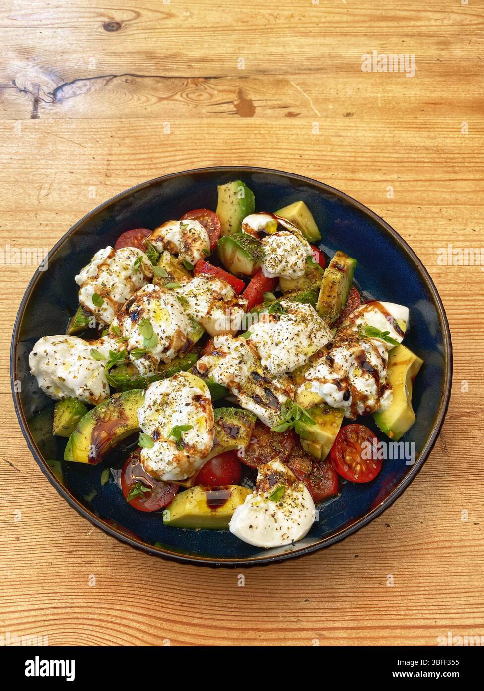 Tomato Avocado and Burrata salad with oil and vinegar dressing - Smartphone Captured Stock Image