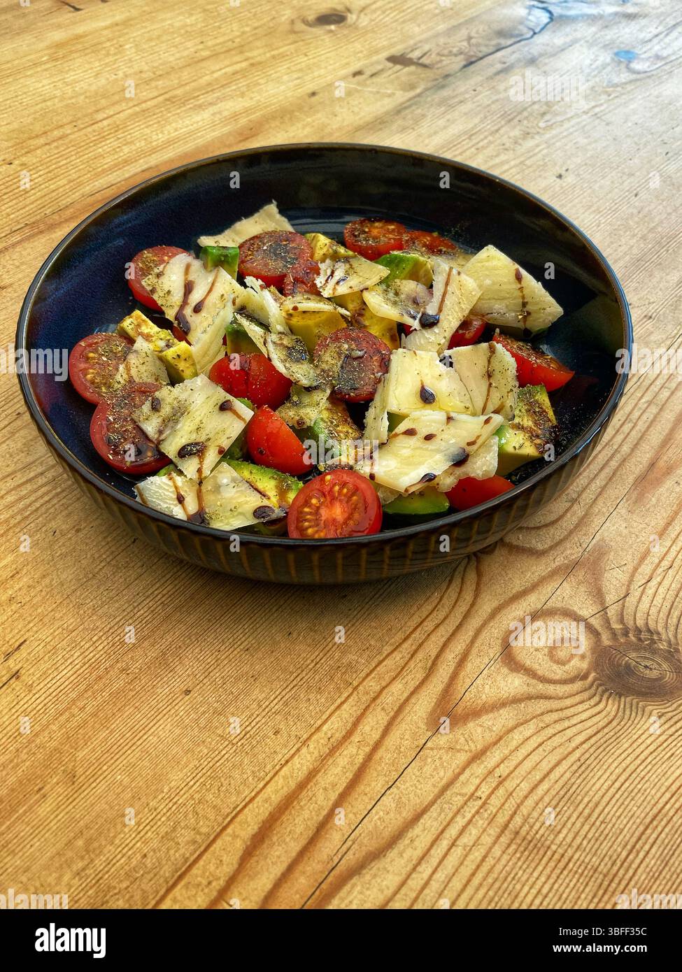 Tomato Avocado and Burrata salad with oil and vinegar dressing - Smartphone Captured Stock Image