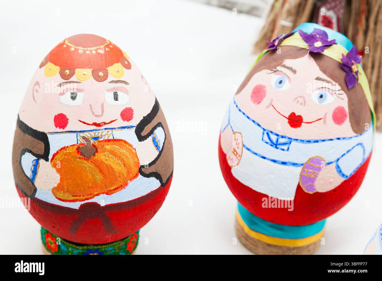 two eggs painted with bright colors in the form of peoples faces. Stock Photo