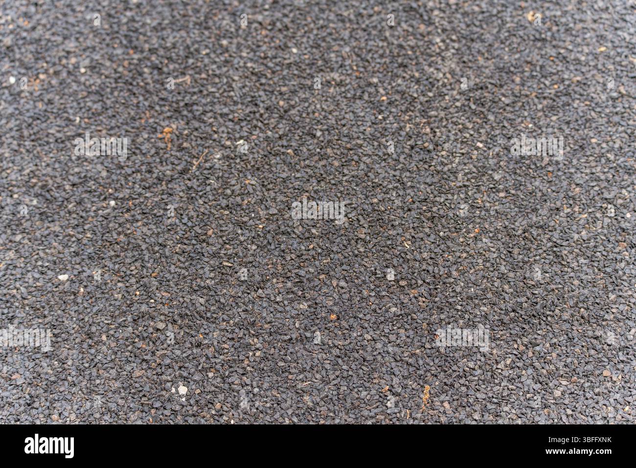 Fine asphalt surface macro shot. Detailed macro shot of a finer asphalt surface with clearly visible pebble structures. The surface appears more compa Stock Photo