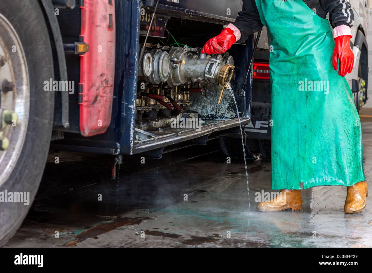 Operator at a tanker truck wash station emptying the compartments of ...