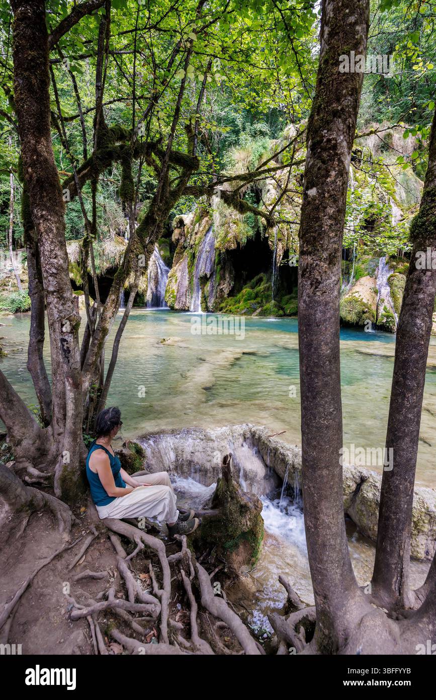 Woman looking at tufa cascade, Cascade des Tufs, Les Planches-pres-Arbois, Jura, France Stock Photo