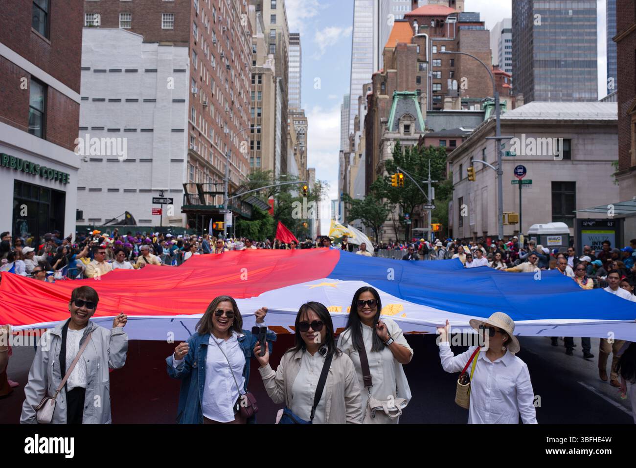 A large Philippine flag is held aloft by a crowd of people during a ...
