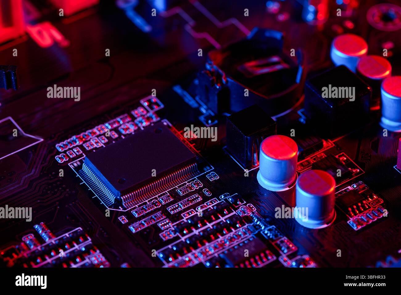 Close-up of a computer motherboard surface with chips, capacitors, and ...