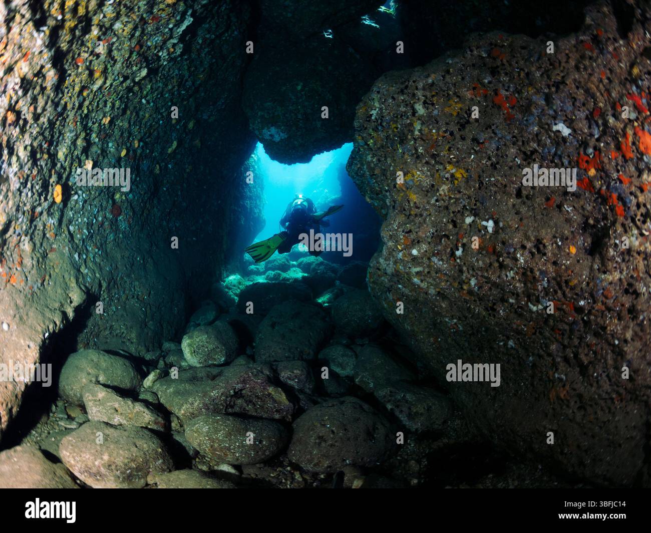 diving through a hole between rocks on the seabed Stock Photo - Alamy