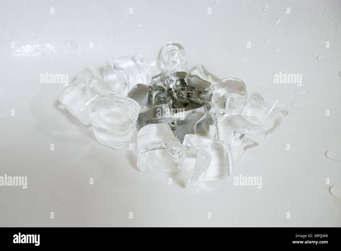 Ice cubes on a plum in a white sink. Stock Photo