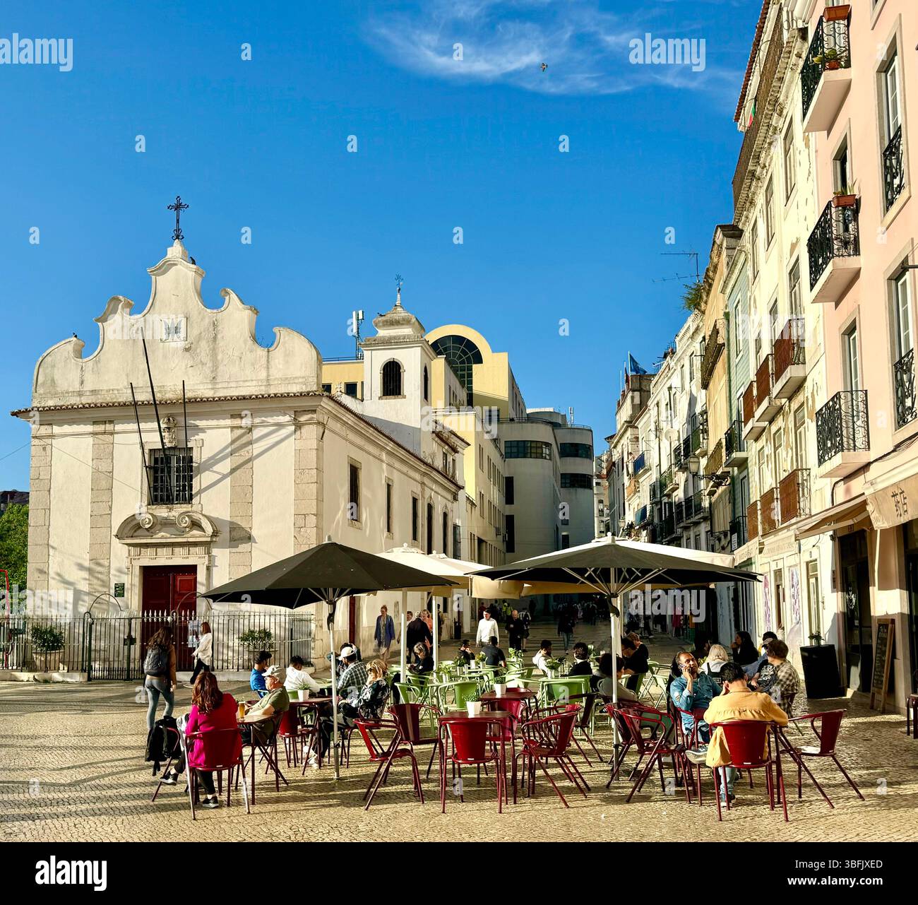 Alfresco dining in a plaza by Capela de Nossa Senhora da Saúde or Chapel of Our Lady of Health in Mouraria district of Lisbon Portugal - Smartphone Captured Stock Image