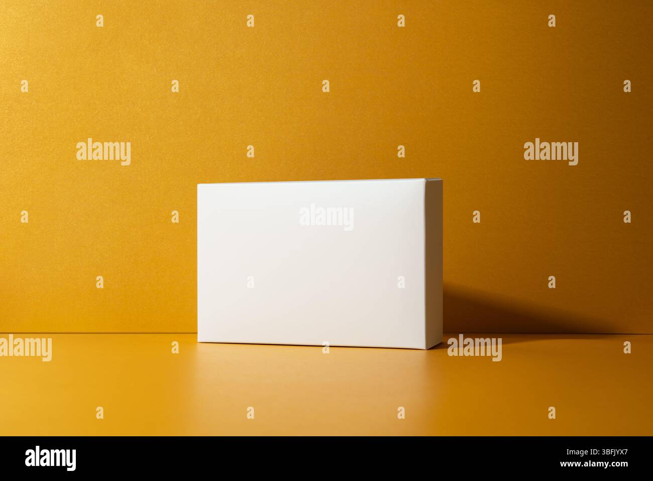 Minimalist white box on golden, yellow background with clean shadows ...