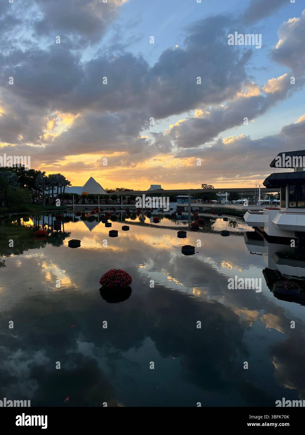 Serene view of quiet water overlooking the park with the sun setting and beautiful clouds reflected in the water - Smartphone Captured Stock Image