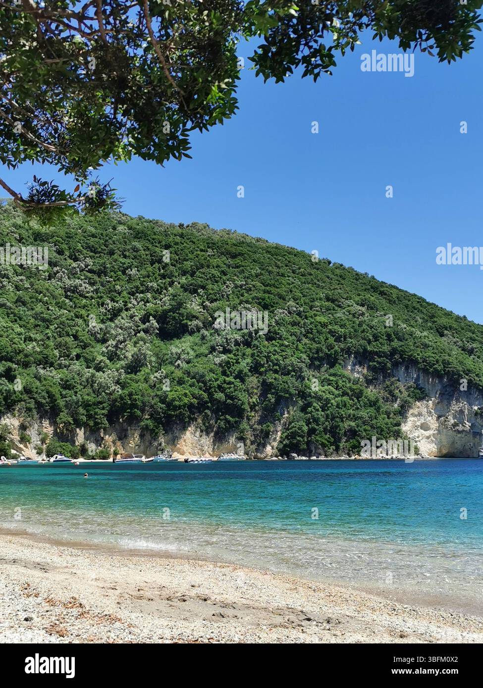 Desimi pebble beach near Nidri on Lefkada Island in Greece. A sheltered bay which is great for boating, paddleboarding, snorkelling and swimming. - Smartphone Captured Stock Image