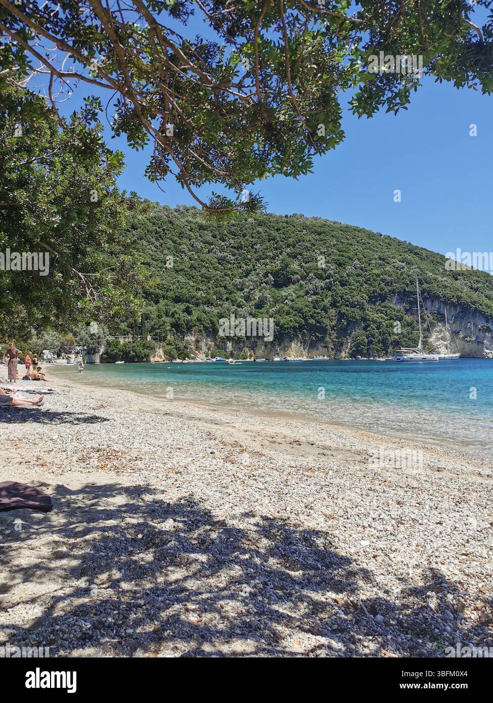 Desimi pebble beach near Nidri on Lefkada Island in Greece. A sheltered bay which is great for boating, paddleboarding, snorkelling and swimming. - Smartphone Captured Stock Image
