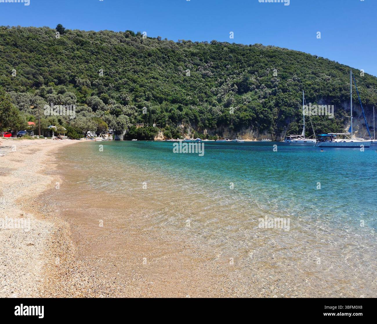 Desimi pebble beach near Nidri on Lefkada Island in Greece. A sheltered bay which is great for boating, paddleboarding, snorkelling and swimming. - Smartphone Captured Stock Image
