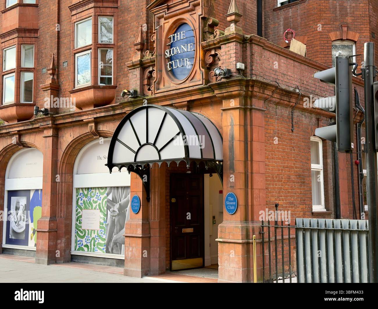 LONDON, ENGLAND – MARCH 16, 2025: The entrance of The Sloane Club featuring its distinctive brick facade and arched entryway. - Smartphone Captured Stock Image