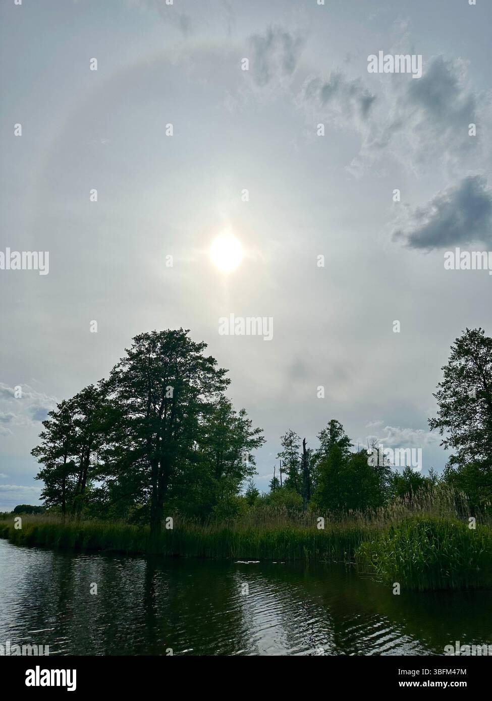 A halo weather phenomenon in late spring over the river Peene in Mecklenburg-Vorpommern, Germany - Smartphone Captured Stock Image