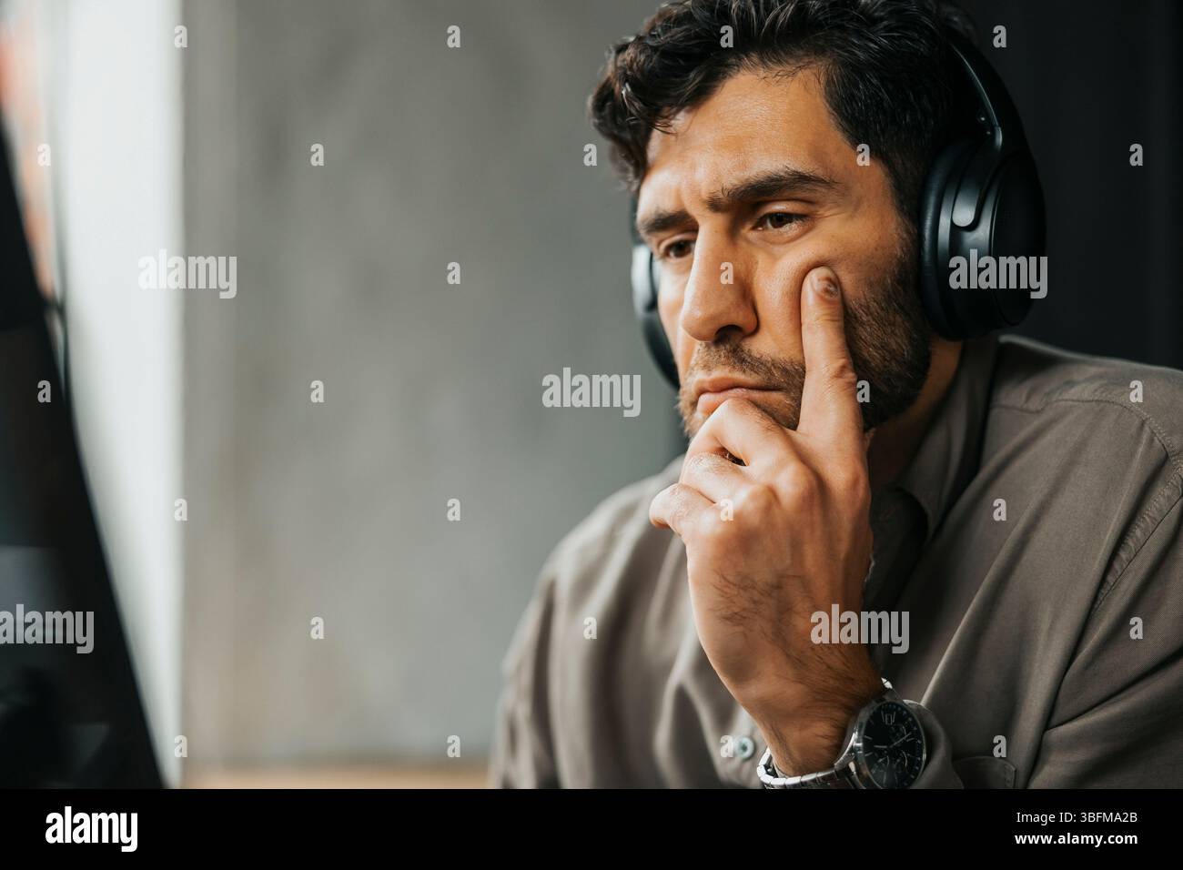 Focused male computer programmer with wireless headphones working at office Stock Photo
