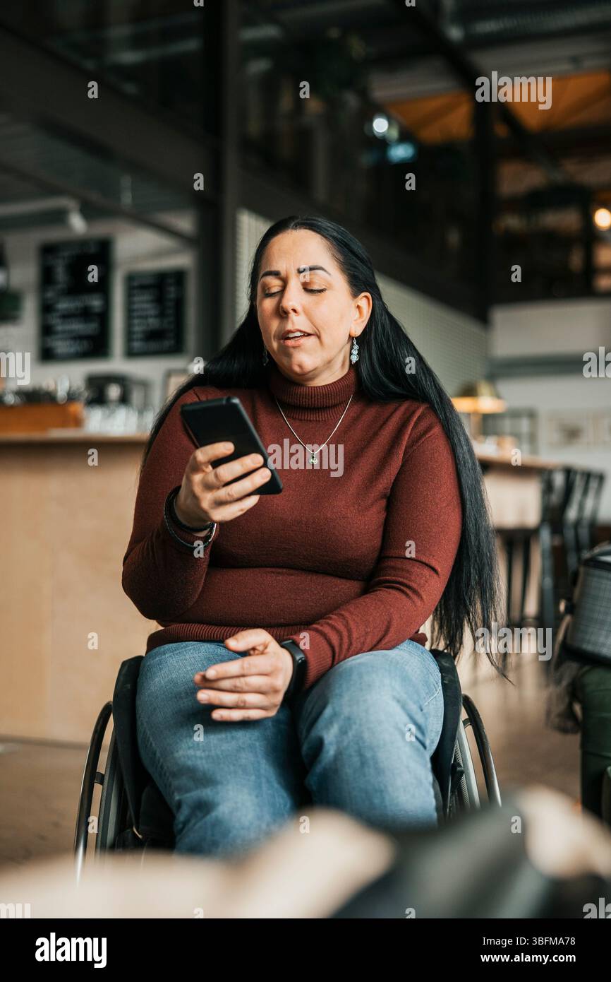 Businesswoman with disability using smart phone at office Stock Photo