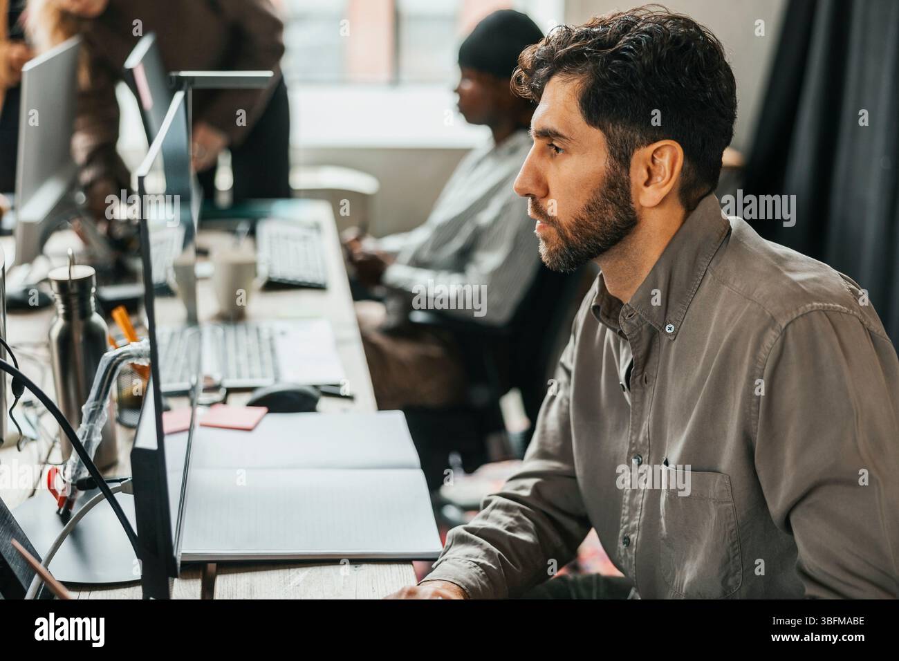 Focused programmer working on computer at tech start up office Stock Photo