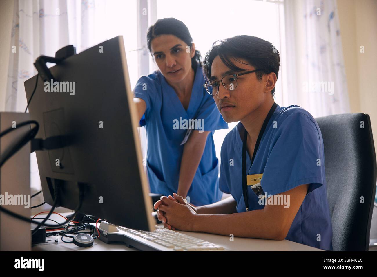 Doctors having discussion over computer in clinic Stock Photo