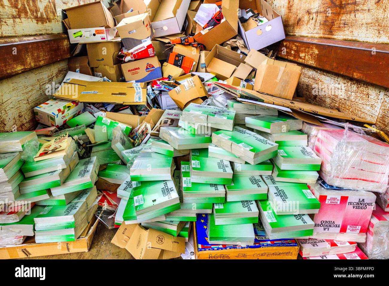 Hundreds of unsealed and unopened college / school video instruction books thrown into a recycling skip - central France. Stock Photo