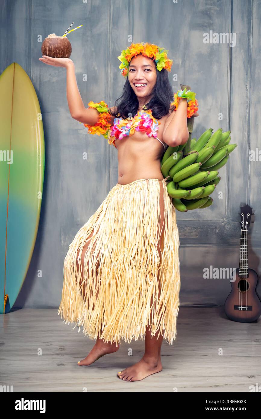 Ethnic cheerful woman in traditional Hawaiian costume holding a bunch ...