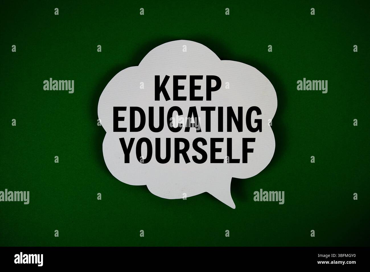 Keep Educating Yourself text with speech bubble on green background Stock Photo