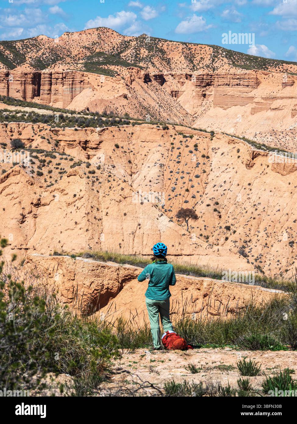 Cyclist looks over the desert, viewpoint,  Gorafe Desert, UNESCO Granada Geopark, Granada province, Andalusia, Spain Stock Photo