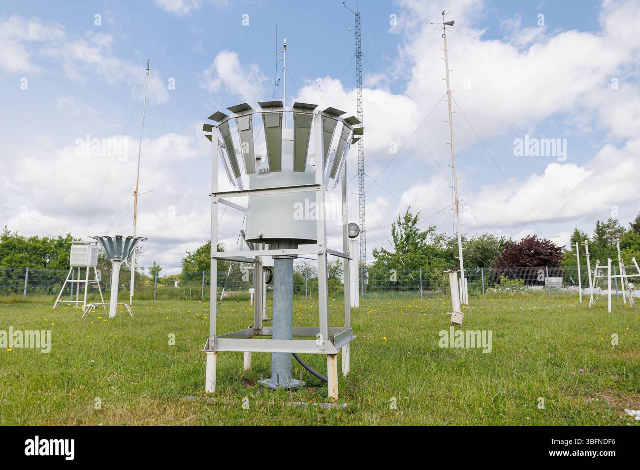 Meteorological station with rain gauge collectors and weather sensors installed on a grassy field. High quality photo Stock Photo