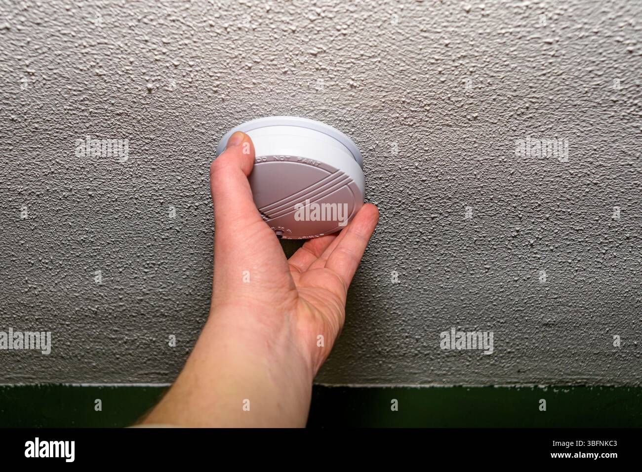 Man installing smoke detector Stock Photo