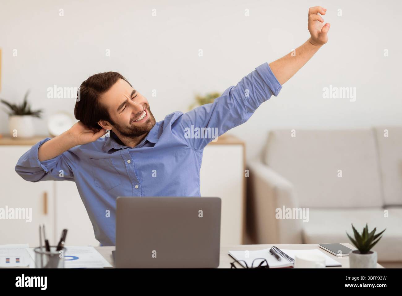 Man Massaging Aching Neck After Work At Computer In Office Stock Photo