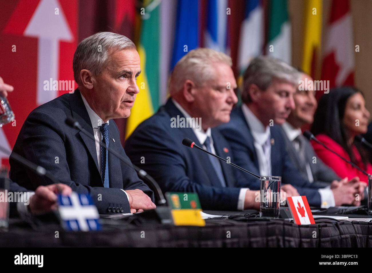 Prime Minister Mark Carney, left, speaks to media following the First