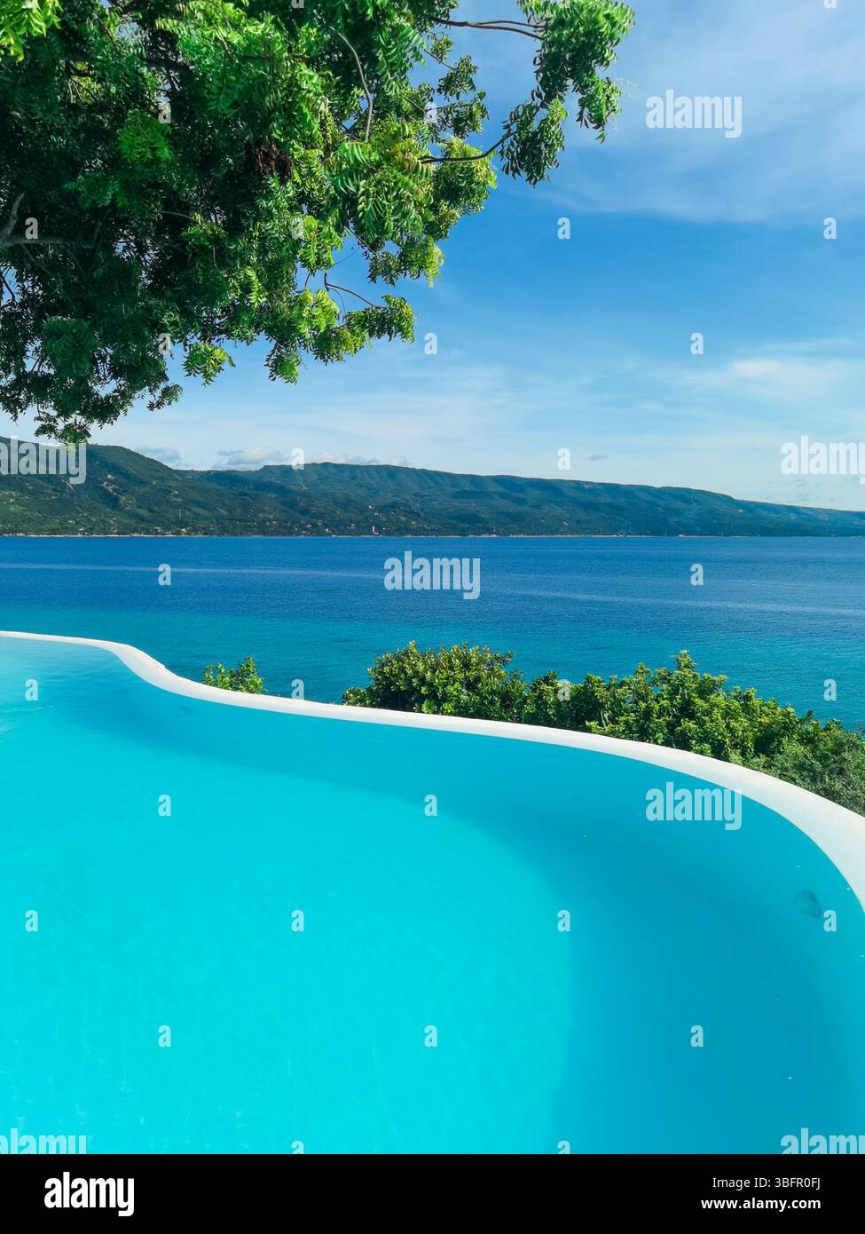 Infinity pool overlooking the sea in perfect harmony. A luxurious setting radiating calm, serenity, and a deep sense of peaceful plenitude. - Smartphone Captured Stock Image