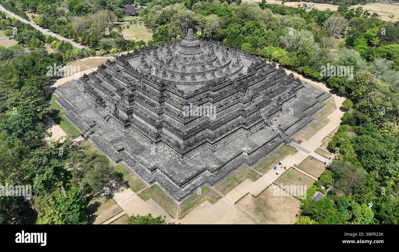The geometric perfection of Borobudur is captured in this drone shot, highlighting the temples massive stone structure and the harmony between sacred Stock Photo