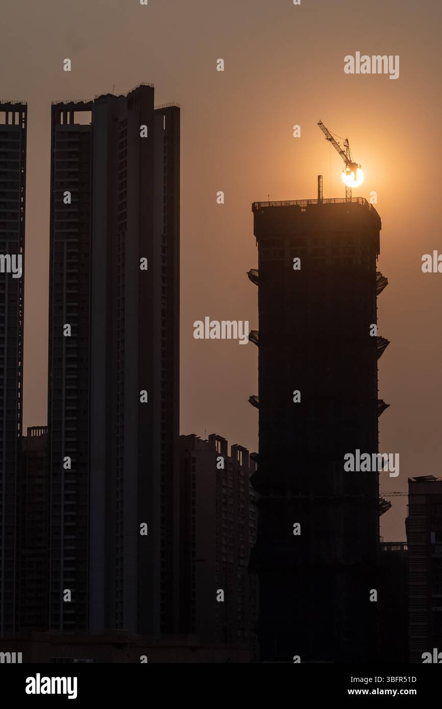A tall construction crane stands atop a developing building in Mumbai ...